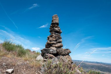 Portekiz 'de Castedo, Torre de Moncorvo' da meşe ağacının yanındaki kayaların üzerinde taş piramit.