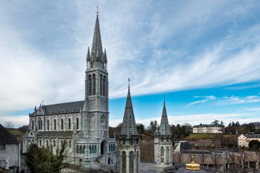 Lourdes Sığınağı 'ndaki kilise. Fransa' nın Pireneler şehrinin ön cephesindeki tapınağın bir kısmıyla birlikte.
