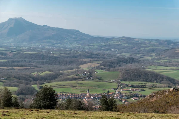 Panoramic view over the town of Ainhoa with green pastures and more mountains in the background in the Basque Country, France