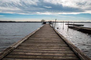Bulutlu bir kış gününde, nehrin üzerindeki ahşap iskele.