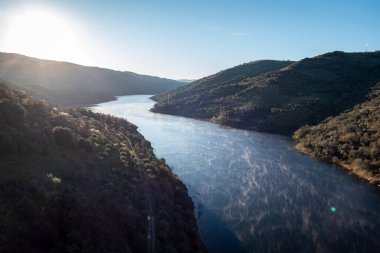 Between mountains the river with small traces of condensation on the water on a cold winter day