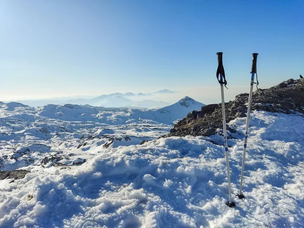 Ski sticks or walking sticks on the snow with icy mountains in the background in Pierre Saint Martin in Pyrenees-Atlantiques, France