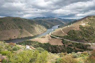 Tepeler ve dağlar arasında Douro nehri ve küçük Coa nehri Portekiz 'deki Coa vadisinde bulutlu bir günde