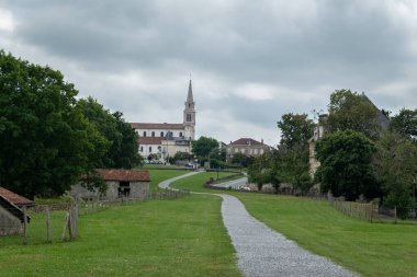 Fransa 'da bulutlu bir günde arka planda Saint James Major Kilisesi ile Bidache şehri üzerinde kısmi görüş