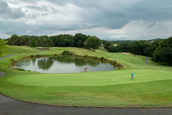 Golfer Lake Background Hitting Ball Very Cloudy Day — Stock Photo, Image