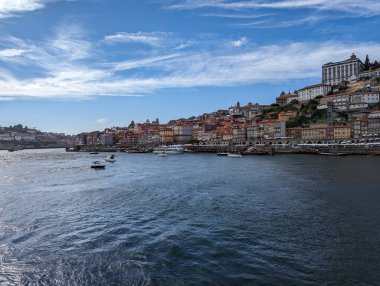 Portekiz 'in eski Porto kasabası Ribeira üzerinde panoramik manzara, renkli evler ve Douro nehri ile suda bazı tekneler