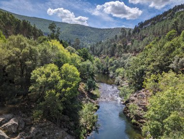 Arouca, Portekiz 'deki tepeler, dağlar ve birçok kayanın arasında Paiva nehri var.