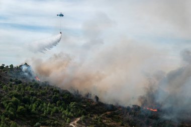 Heights Muharebesi: Helikopter havada çok fazla duman bırakan yıkıcı bir yangına su bırakıyor