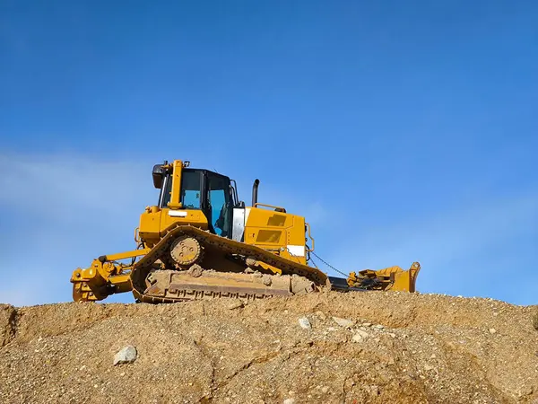 Backhoe excavating earth for the construction of a road