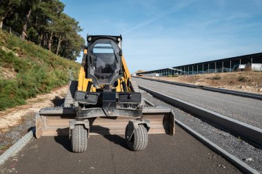 Yapım aşamasındaki bir yolu dengeleyen not makinesi