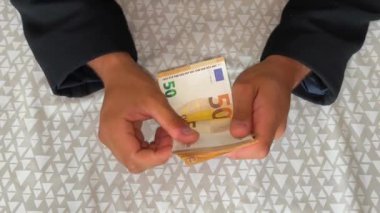 Masadaki odada oturmuş Euro banknotlarını sayan erkek eller. Bankacılık ve finans. İş hayatı. Mali iş kavramı