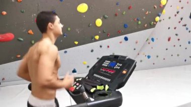 Spor salonundaki koşu bandında formasyonunu geliştiren genç sporcunun videosu.