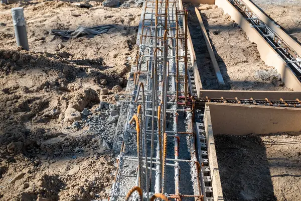 Construction site with the construction of concrete foundations and the iron frame for a residential construction