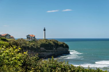 Fransa 'nın Bask Bölgesi' nde Biarritz 'de deniz kenarında bir evi olan kayalık bir yüksekliğin üstünde deniz feneri.