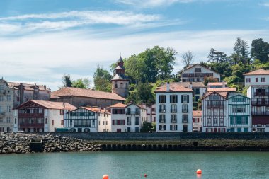 Saint Jean de Luz 'un nehir kıyısında Fransız Bask ülkesinin tipik evleri ve renkleriyle panoramik bir manzara.