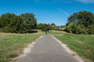Bir golf sahasının kalbinde ve ağaçlarla çevrili, boş ve eğlenceli bir yol.