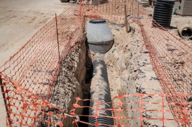 Excavation work on a construction site with exposed pipes for the basic sanitation network clipart