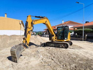 Sürüngen kepçesi bir yerleşim yerinin ortasına halk sağlığı için hendek kazıyor.