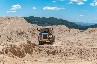 Kurak, engebeli toprak taşıma arazisinde bir çöp kamyonu.