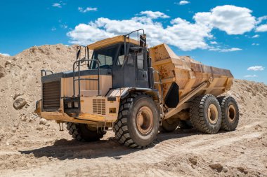 Side view of a large dump truck working in a quarry on shitting and transporting land