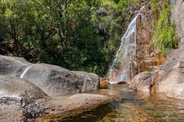 Cela Cavalos Şelalesinin Portekiz 'deki Serra da Estrela' da doğa tarafından çevrelenmiş yan görüntüsü