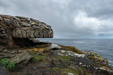 Çok bulutlu bir günde İspanya 'nın Punta Frouxeira şehrinde denize bakan eski bir sığınak.