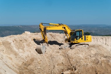 Sürüngen kazıcı, güneşli bir günde tarım sulama için su depolamak üzere bir baraj inşa ediyor.