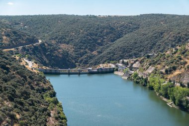 Dağlarla ve yemyeşil topraklarla çevrili Portekiz 'deki Douro Nehri üzerindeki Miranda do Douro hidroelektrik barajı.