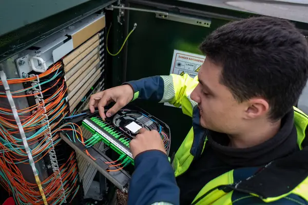 Fiber optik teknisyen arızadan etkilenen müşterilere ağ erişimini geri getirmek için bir dolap üzerinde onarım yapıyor