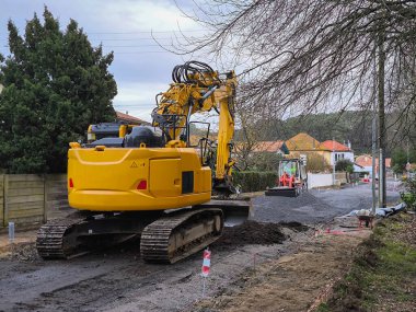 Sürüngen kazıcısı bir yerleşim bölgesindeki kaldırım onarım çalışmasında.