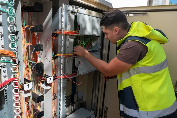Müşterilere ağ kalitesini sağlamak için fiber optik kabine üzerinde bakım yapan teknisyen