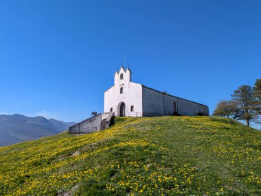 Fransız Bask Bölgesi 'ndeki Musculdy' de Aziz Anthony Kilisesi güneşli bir günde yemyeşil bir tepenin üzerinde kır çiçekleriyle görkemli bir şekilde duruyordu.