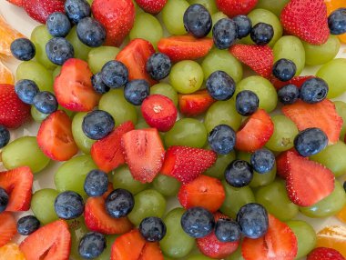 Çeşitli taze meyveli meyve salatası; üzümler, çilekler ve yabanmersinleri, sağlıklı bir aperatif veya tatlı için hazır.