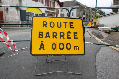 Fransa 'da bir yolun ortasında yol barikatı işareti ve Fransızca açıklama
