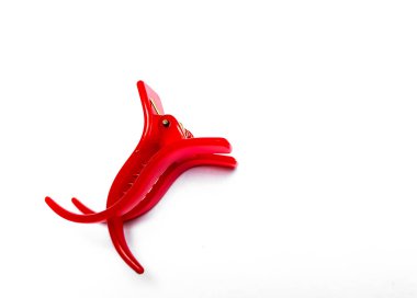 Saç tokası beyaz arkaplanda izole edilmiş. Kızın plastik saç tokası, kırmızı renk.