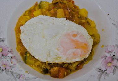 Çeşitli kızarmış sebzeler ve üzerine kızarmış yumurta karışımı.