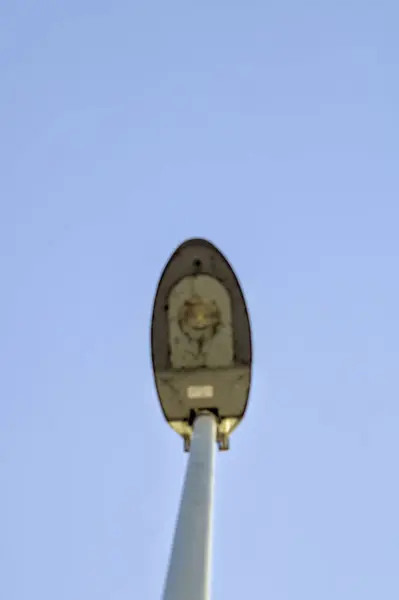 Mavi gökyüzünde tek başına uzun bir sokak lambası