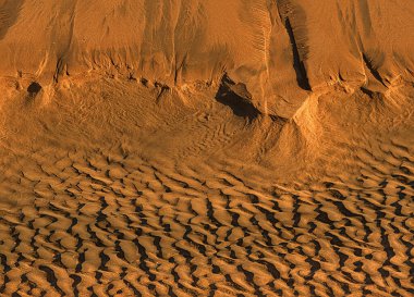 Dalgaların bıraktığı şekillerle kumsaldaki oyuklar.