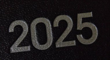 Üzerinde 2025 yılı yazan siyah bir deri planlayıcının kapağı..
