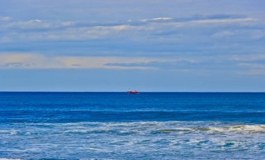 Açık denizlerde balık tuttuktan sonra limana dönen balıkçı teknesi.