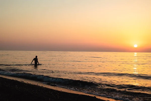 Yunanistan Kamari plajında bir adamın gündoğumu silueti. Yüksek kalite fotoğraf