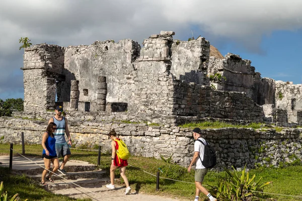 TULUM, Meksika - Şubat 2023: Ziyaretçiler gün boyunca Tulum harabelerinde gezinerek, kendilerini arkeolojik harikaya daldırıyorlar