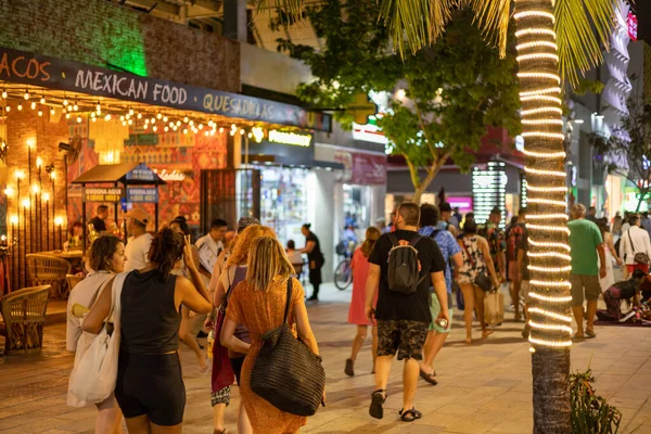 PLAYA DEL CARMEN, Meksika - 2023 Şubat 'ı 5. Bulvar geceleri hareketli bir kalabalık caddeleri doldururken, renkli ışıklarla yıkanırken.