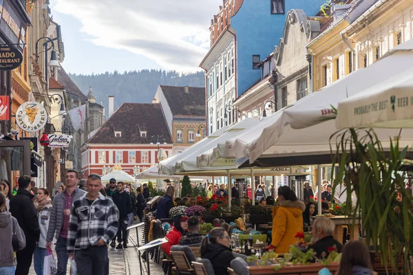 Brasov, Romanya - 5 Kasım 2023 - Strada Republicii 'deki restoranların arasında yürüyen ziyaretçiler. Yüksek kalite fotoğraf