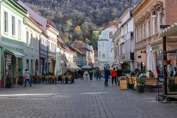 Brasov, Romanya - 5 Kasım 2023 - Strada Republicii 'deki restoranların arasında yürüyen ziyaretçiler. Yüksek kalite fotoğraf