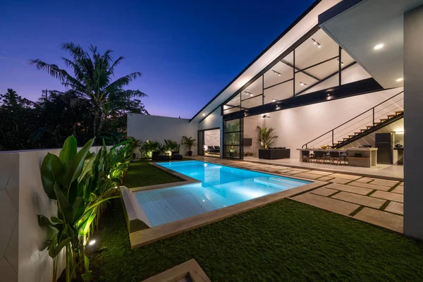 Tropischer Villenblick Mit Garten Pool Und Offenem Wohnzimmer Bei Sonnenuntergang Stockfoto