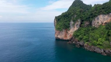 Top fly over and aerial view of Pileh lagoon in Phi Phi island of Thailand show beautiful area. Blue water in valley surround with mountain and some boat sail in ocean.