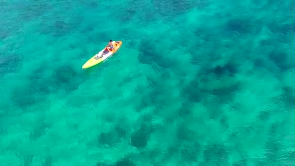 透き通ったエメラルド海と熱帯エキゾチックな風景の中でスポーツカヤックを楽しむ男の空中ドローンビデオ — ストック動画