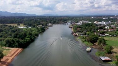Aerial overview and descending flight at the Kwai noi river and surrounding landscape in the Kanchanaburi province, Thailand.