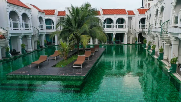 View of swimming pool inside the hotel. Green color of swimming pool at the sunny day.